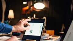 old-couturier-checking-fashion-sketches-atelier-working-modern-designs-with-laptop-tablet-experienced-designer-searching-handmade-models-online-needlework-handheld-shot-min